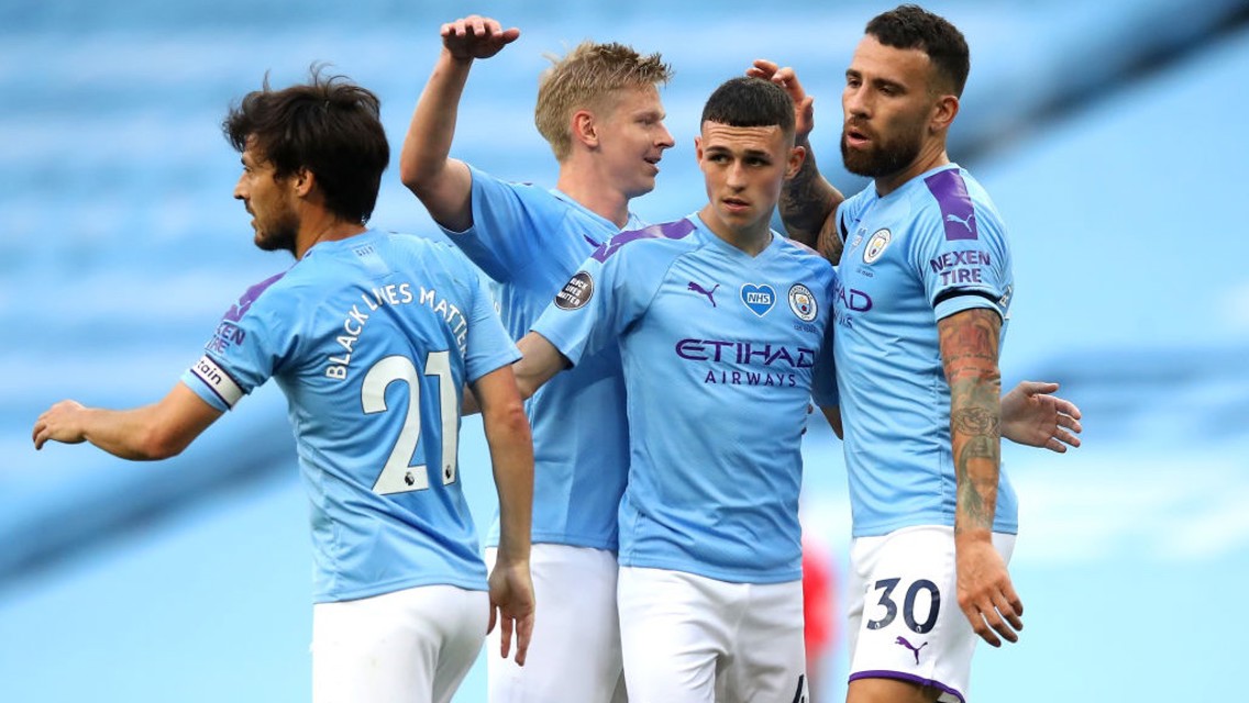 CENTRE OF ATTENTION: The players gather around Foden to congratulate him after the superb goal.
